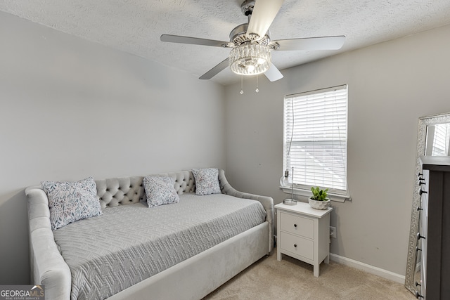 carpeted bedroom with a textured ceiling and ceiling fan