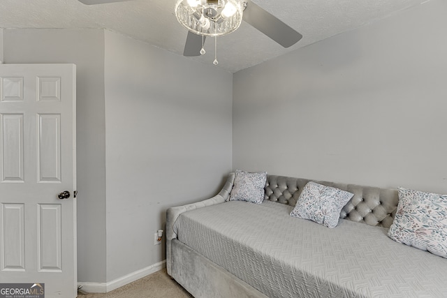 bedroom featuring a textured ceiling, light carpet, and ceiling fan