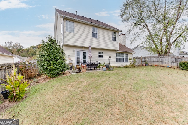 rear view of house with a patio, a yard, and french doors