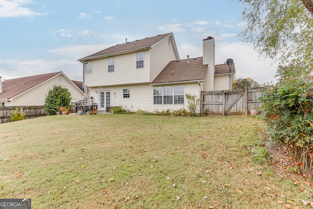 rear view of house featuring french doors and a yard