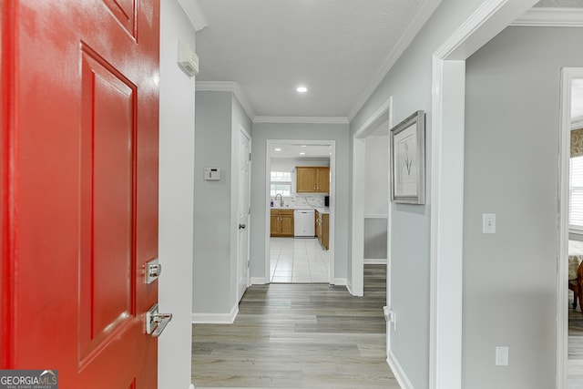 corridor featuring sink, wood-type flooring, and ornamental molding