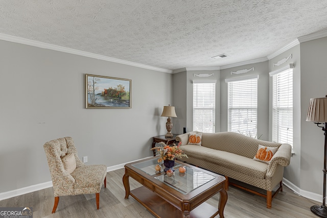 living room featuring ornamental molding, light hardwood / wood-style floors, and a textured ceiling