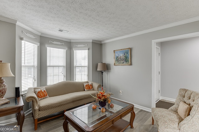 living room featuring hardwood / wood-style flooring, a textured ceiling, and crown molding