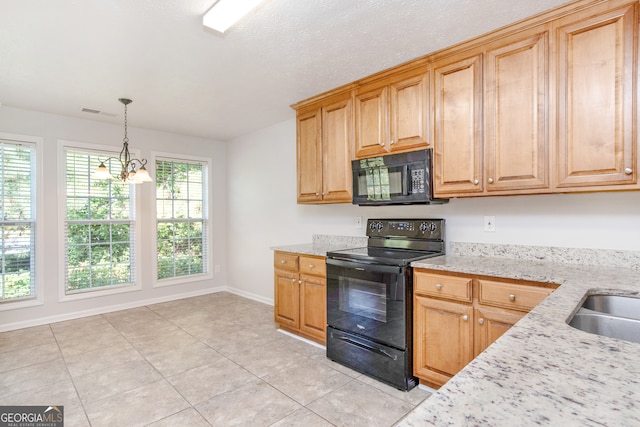 kitchen featuring black appliances, light stone counters, decorative light fixtures, a notable chandelier, and light tile patterned floors