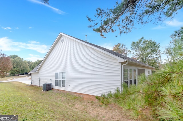 view of property exterior featuring central AC and a lawn