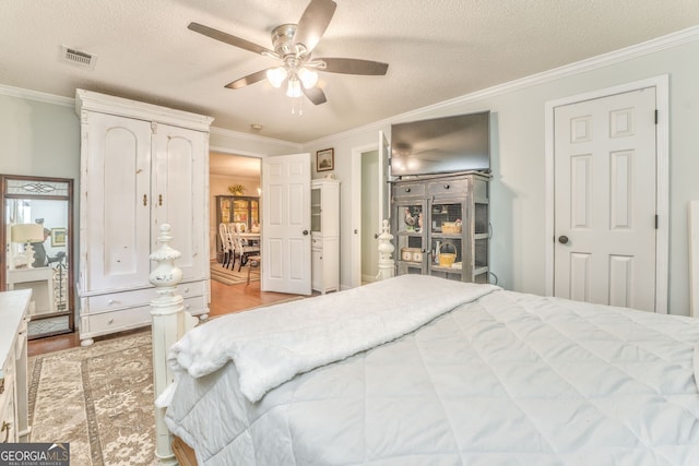 bedroom featuring visible vents, a textured ceiling, and ornamental molding