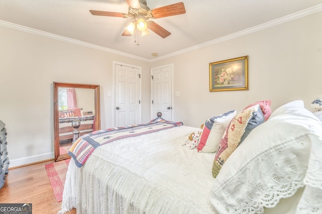 bedroom featuring light wood finished floors, ceiling fan, ornamental molding, and baseboards