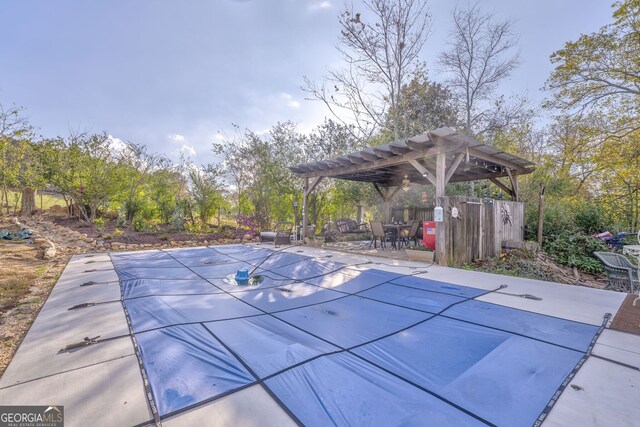 view of swimming pool with a patio area, a covered pool, and a pergola