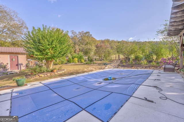 view of swimming pool featuring a patio and a covered pool