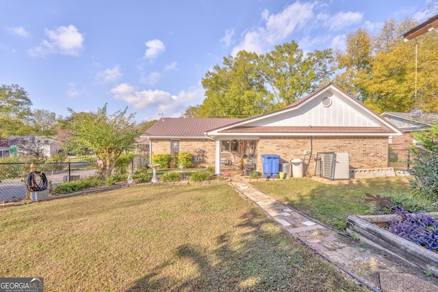 view of front facade featuring brick siding, fence, and a front lawn