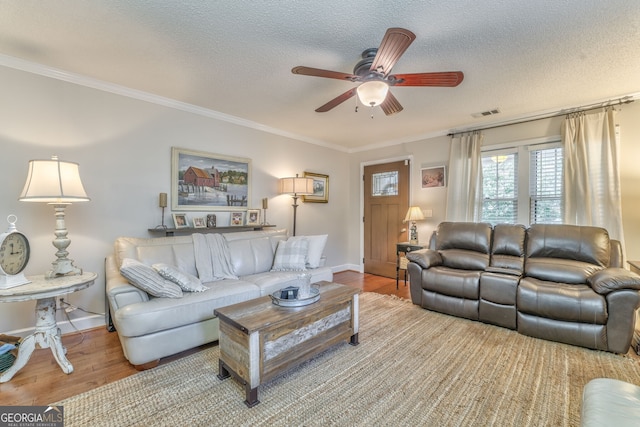 living room featuring a ceiling fan, crown molding, a textured ceiling, and wood finished floors