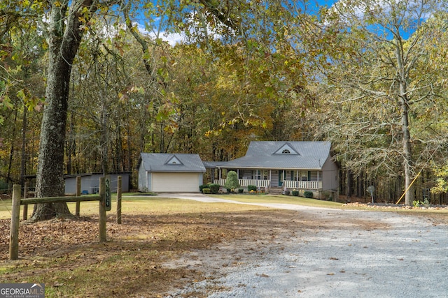 view of front of property featuring an outbuilding, a garage, and covered porch