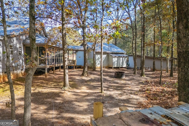 rear view of house featuring a deck, a garage, and a sunroom