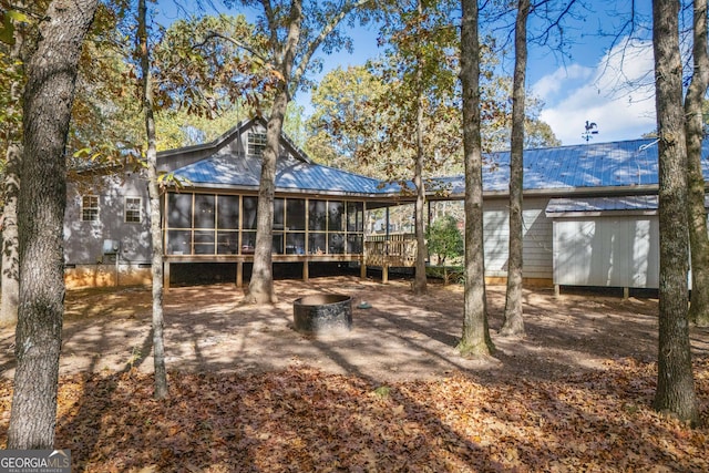 back of property with a sunroom and a wooden deck