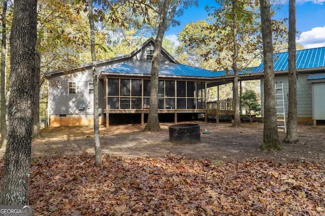 back of house featuring a sunroom and a wooden deck