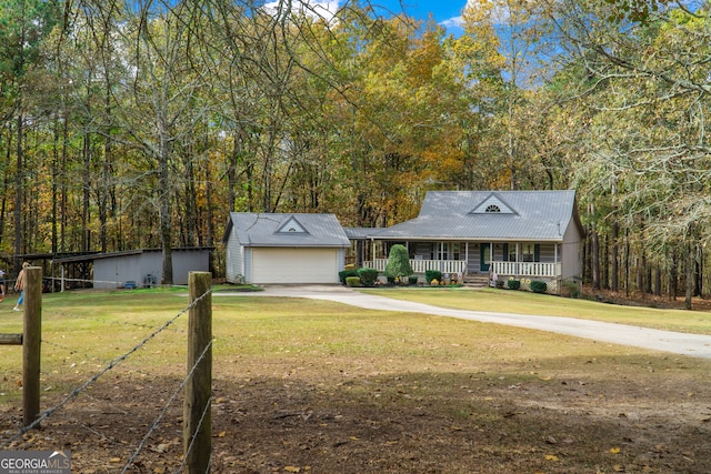 view of front of property with a front lawn, an outbuilding, a garage, and a porch