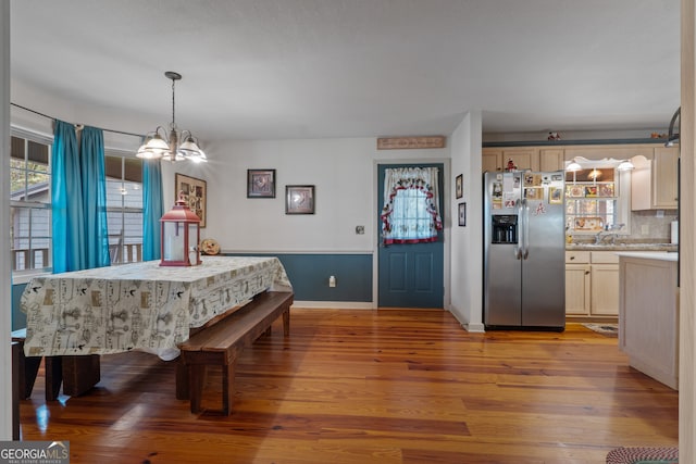 dining space with an inviting chandelier and light hardwood / wood-style flooring