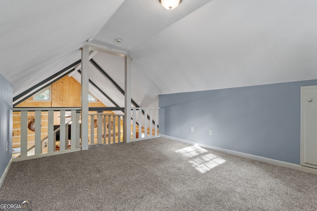 additional living space featuring vaulted ceiling and carpet floors