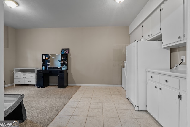 kitchen with white cabinets, light colored carpet, and white refrigerator