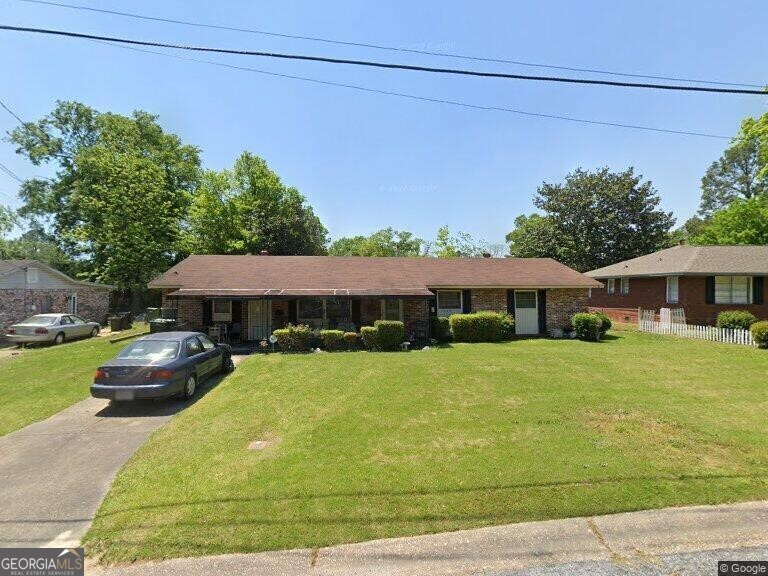 ranch-style home featuring a front lawn