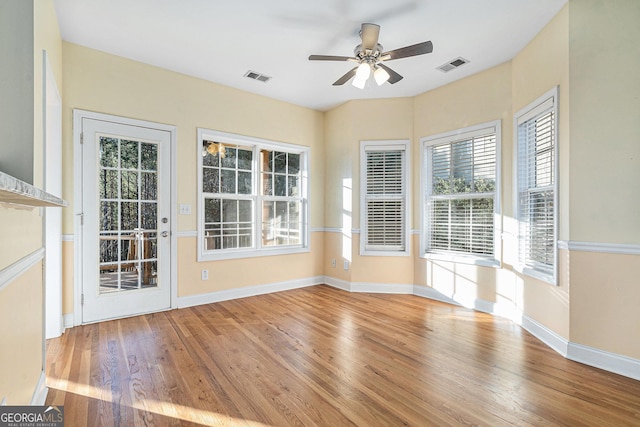 empty room with ceiling fan and light hardwood / wood-style floors