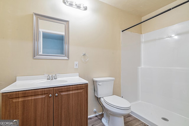 bathroom with walk in shower, toilet, vanity, and hardwood / wood-style flooring