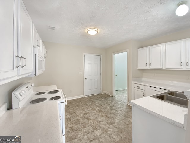 kitchen with white appliances, white cabinets, and a textured ceiling