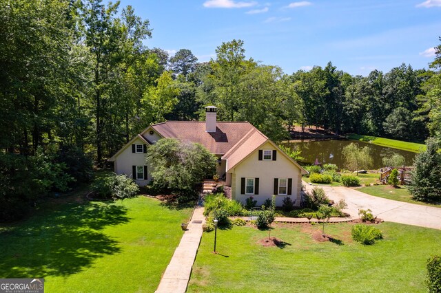 view of front of home with a front yard and a water view