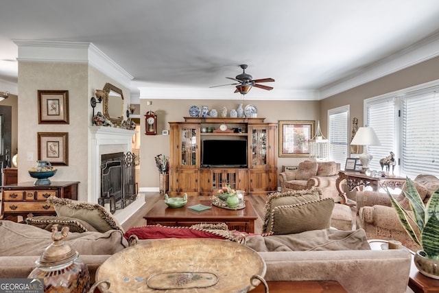 living room featuring hardwood / wood-style floors, ceiling fan, and crown molding