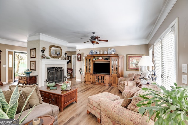 living room with ceiling fan, light wood-type flooring, a tile fireplace, and ornamental molding