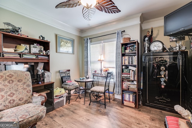 living area with ornamental molding, light wood-type flooring, and ceiling fan