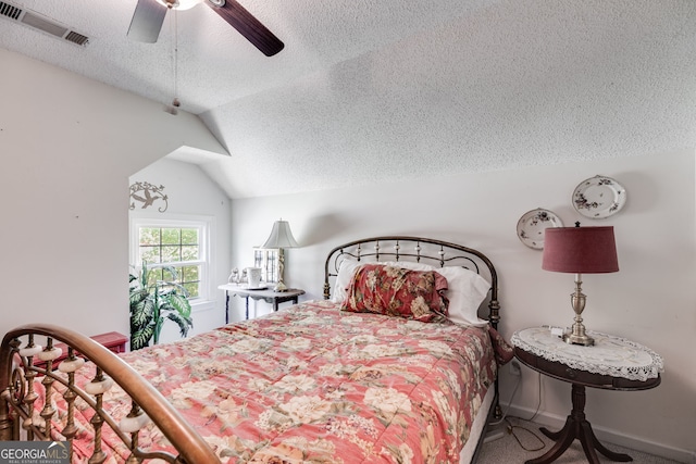 bedroom with a textured ceiling, lofted ceiling, ceiling fan, and carpet floors