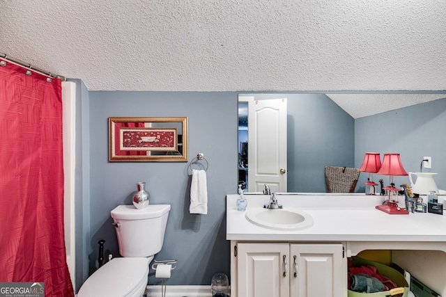 bathroom with vanity, toilet, and a textured ceiling