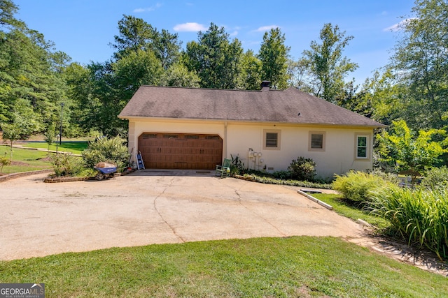 view of side of property with a garage and a lawn