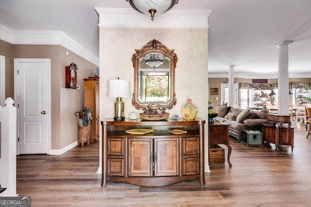 bar featuring crown molding, dark hardwood / wood-style flooring, and decorative columns