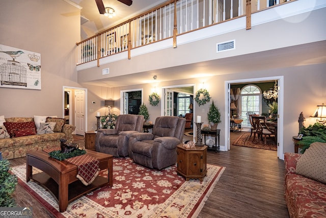 living room with ceiling fan, dark hardwood / wood-style flooring, and a high ceiling