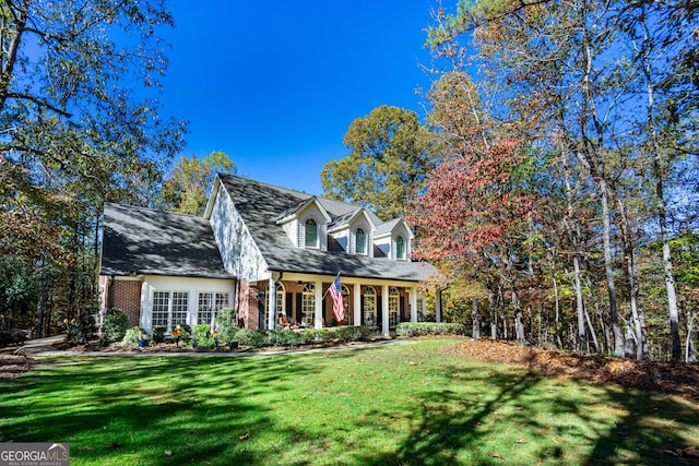 cape cod home with a front lawn