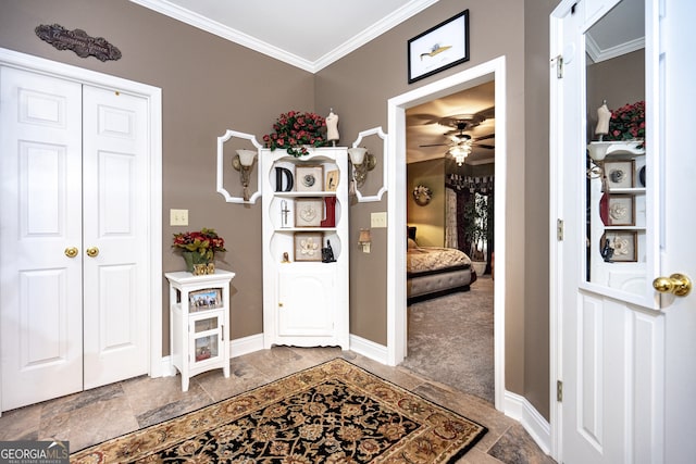 carpeted foyer featuring ceiling fan and crown molding