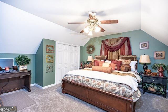 carpeted bedroom with a closet, vaulted ceiling, and ceiling fan