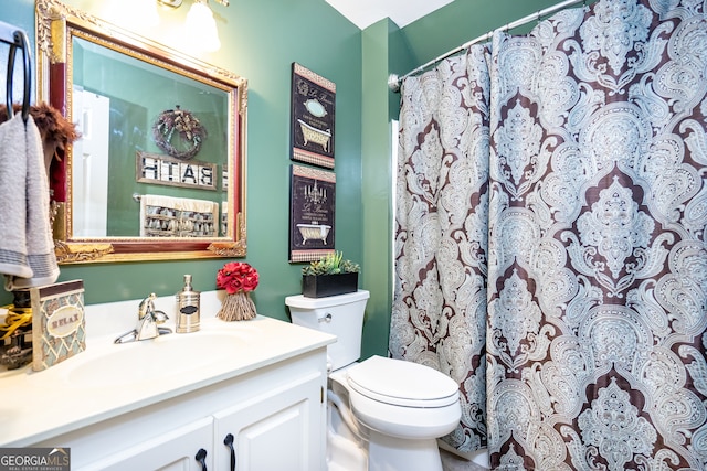 bathroom featuring vanity, toilet, and curtained shower