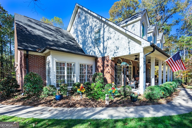 view of side of property featuring ceiling fan and a porch