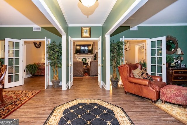 foyer entrance with wood-type flooring, french doors, and ornamental molding