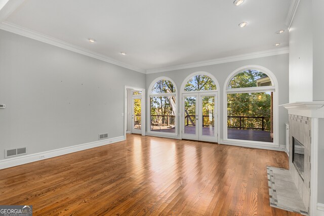 unfurnished living room with light hardwood / wood-style floors and ornamental molding