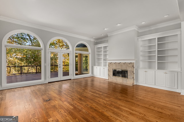 unfurnished living room featuring a fireplace, ornamental molding, and hardwood / wood-style flooring