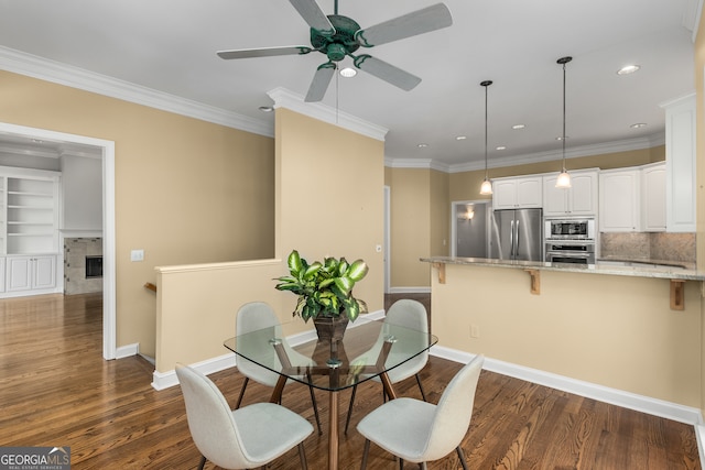 dining room with crown molding, ceiling fan, and dark wood-type flooring