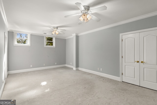 spare room featuring light carpet, ceiling fan, and ornamental molding