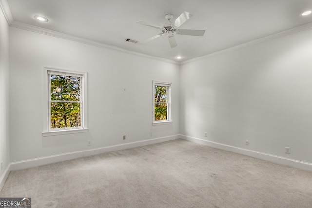 carpeted spare room with ceiling fan and ornamental molding