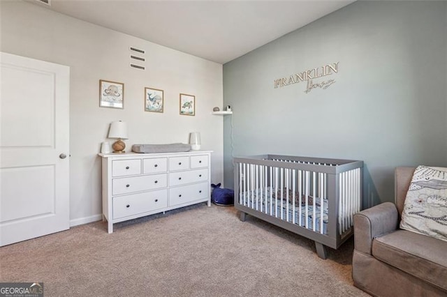 bedroom with light colored carpet and a nursery area