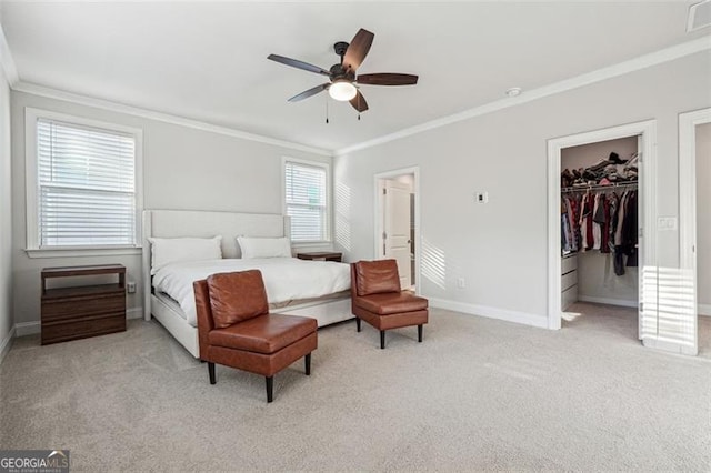 bedroom featuring light carpet, ceiling fan, a spacious closet, crown molding, and a closet