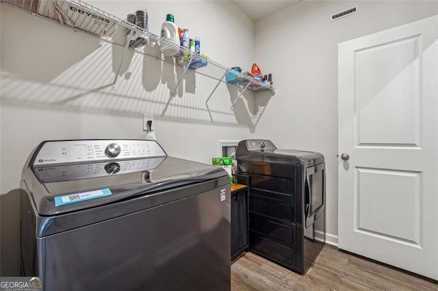 laundry room featuring hardwood / wood-style flooring and washer and dryer